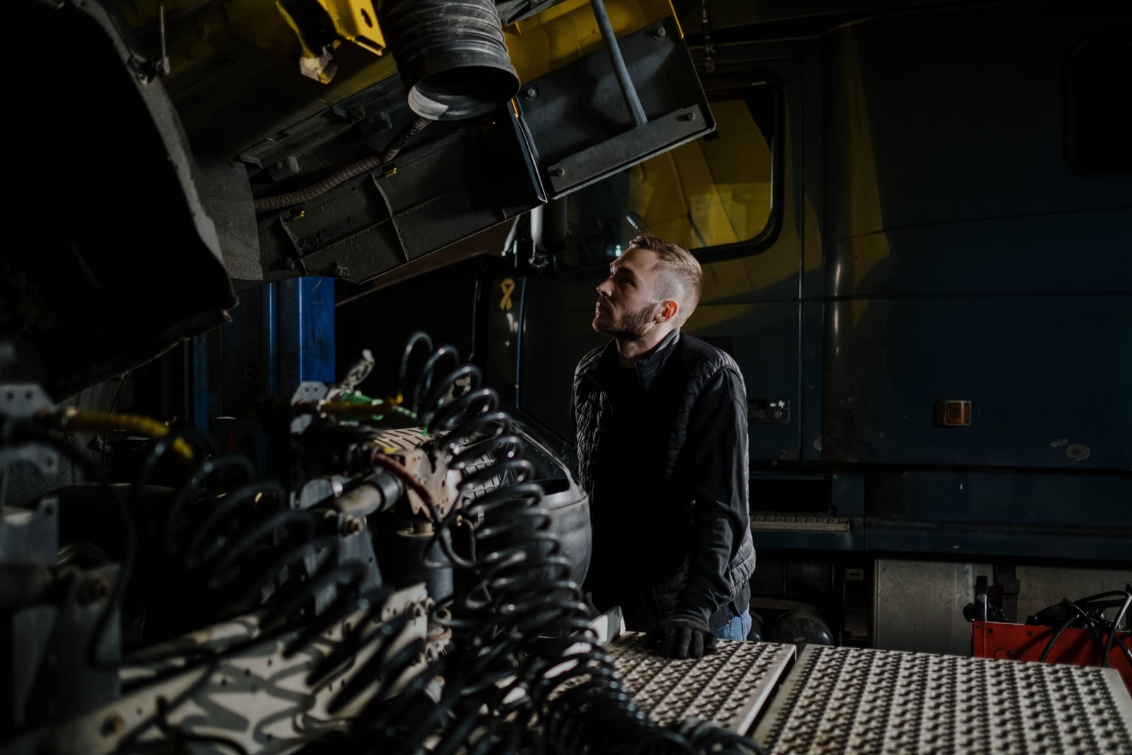 Mechanic standing beside a truck in a workshop